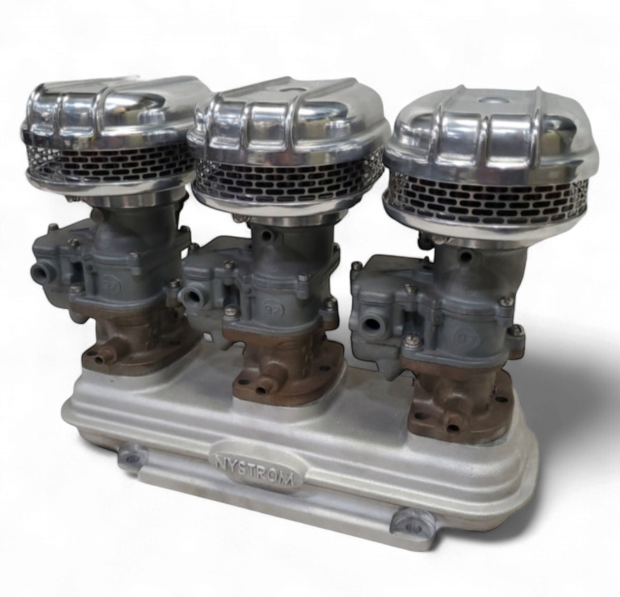 Triple Stromberg 97 air cleaners installed on three-carb intake manifold showing polished finned housings and carburetors